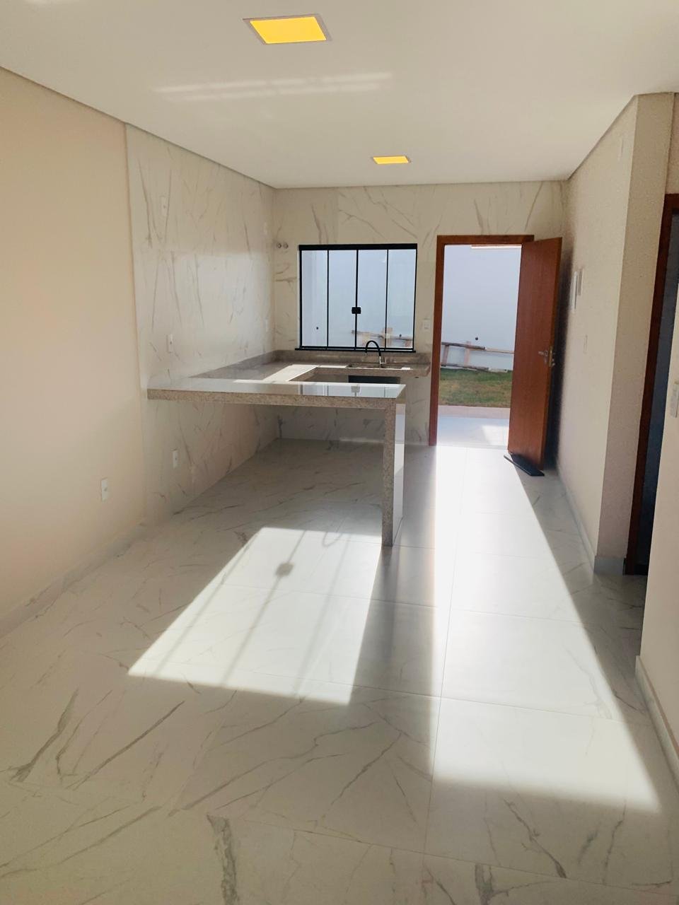 Cozinha com bancada em granito e revestimento em mármore